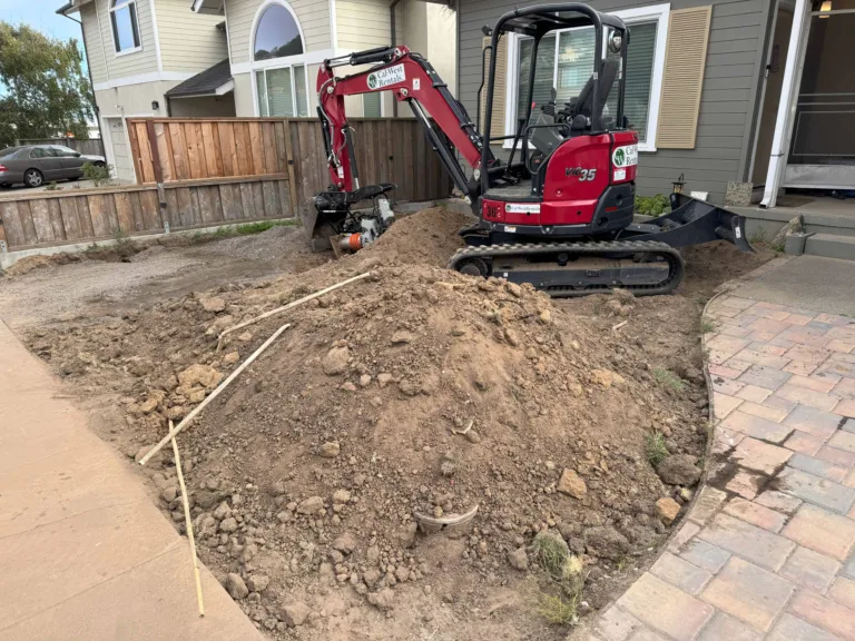 Mini excavator grading a residential front yard