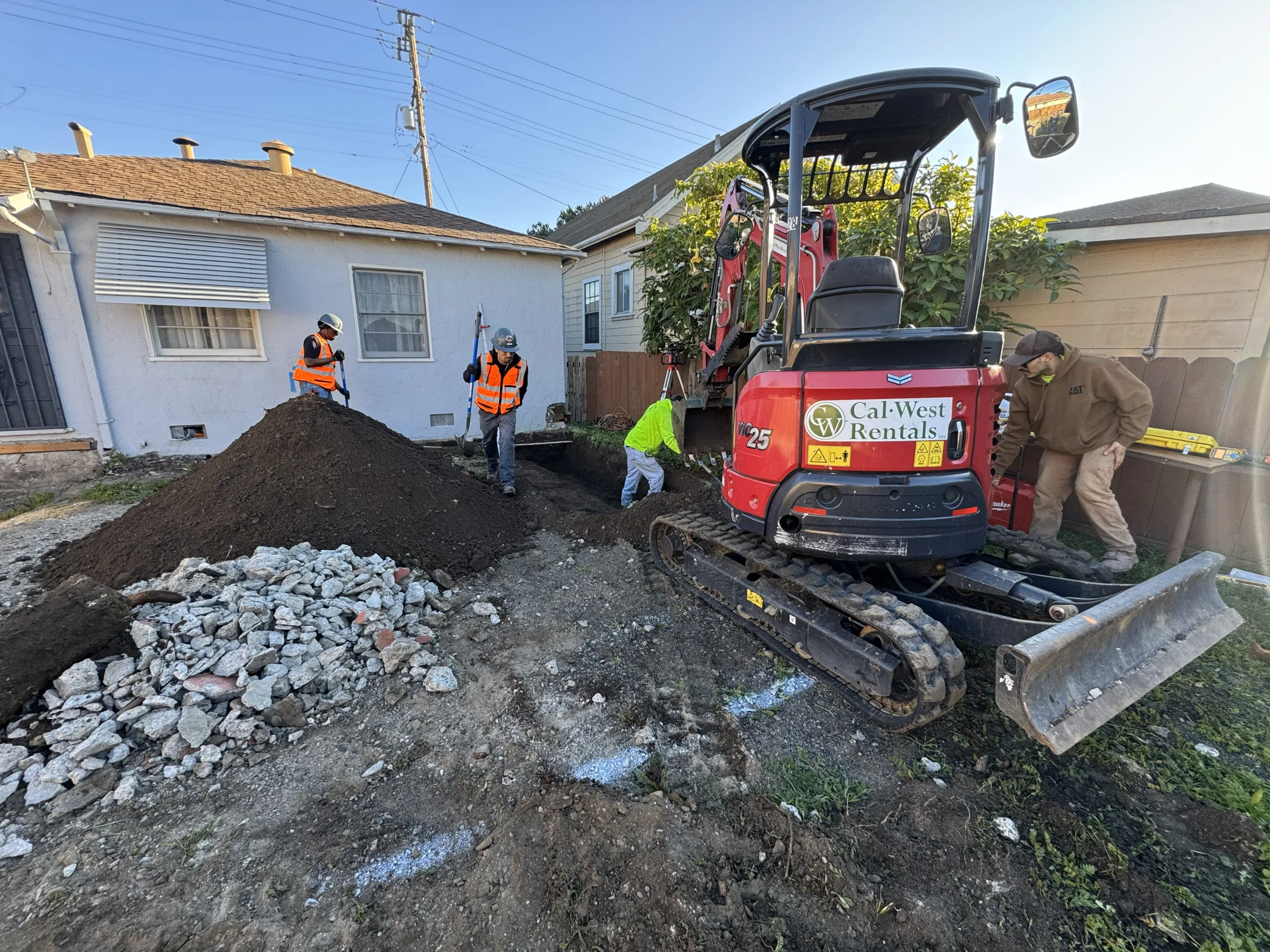 Excavator and crew of laborers working to excavate a foundation