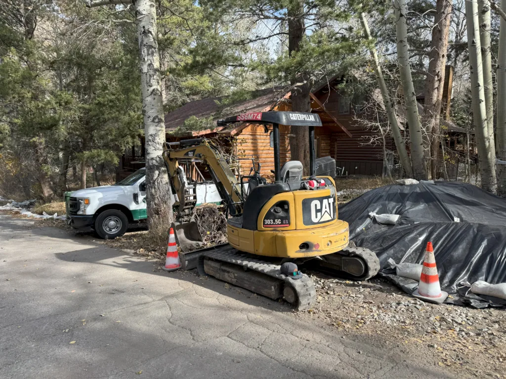 A CAT 303.5 and F250 truck parked at a residential project site in June Lake, CA