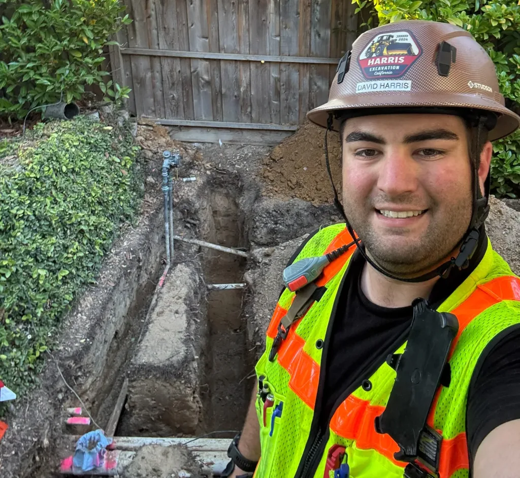 Smiling worker next to a completed trench