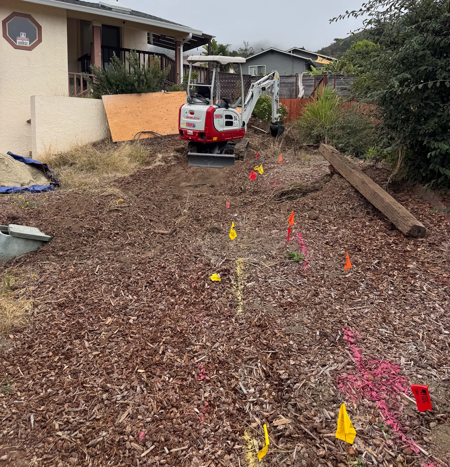 mini excavator and utility markings on a residential site